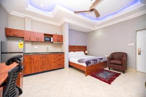 a bedroom with a bed and a kitchen with a sink at XTENDED STAY Gh in Accra