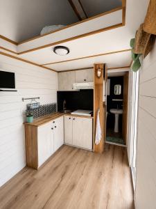 a kitchen with white cabinets and a wooden floor at No 7 Plasmolen in Middelaar