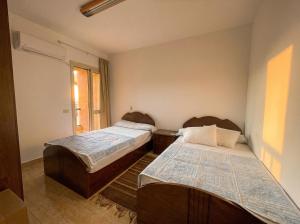 a bedroom with two beds and a window at 396 Blumar Chalet North Coast Sidi-abdelrahman families & couples only in El Alamein +19 photos