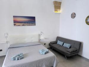 a bedroom with a bed and a couch at Monolocale Central Station in Brindisi +14 photos