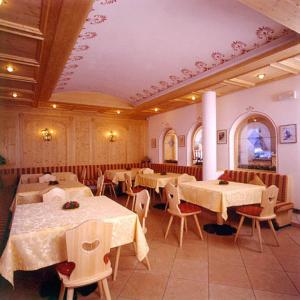 ein Esszimmer mit Tischen und Stühlen in der Unterkunft Hotel Scoiattolo in Wolkenstein in Gröden
