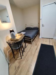 a bedroom with a bed and a table with a laptop at Merginn Guest House in Blackpool