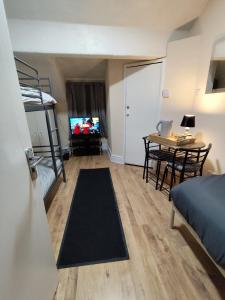 a small room with a bed and a desk and a television at Merginn Guest House in Blackpool +22 photos
