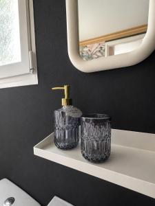 a bathroom shelf with a bottle of soap and a mirror at No 7 Plasmolen in Middelaar +4 photos
