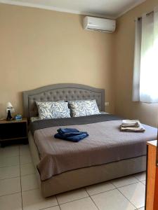 a bedroom with a bed with a blue shirt on it at Joan's House in Nea Potidaea