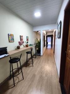 a hallway with two stools and a counter in a room at Pousada Hangar- Seu familiar e aconchegante espaço em Belém in Belém