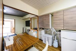 a room with a kitchen with a table and a sink at yadobankkukomae19 in Fukuoka