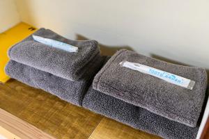 two towels sitting on the floor with a toothbrush at yadobankkukomae19 in Fukuoka