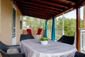 a table and chairs on a screened porch with a view of trees at Joan's House in Nea Potidaea
