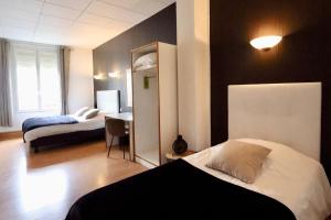 a hotel room with two beds and a mirror at Hotel du Pot d'Etain in Chalons en Champagne