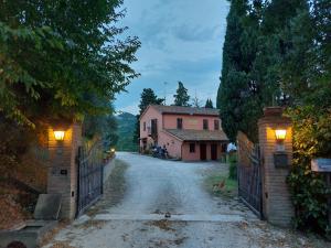 an empty street with a gate and a house at B&B Cà Giovanni Country Resort Pet Friendly in Urbino
