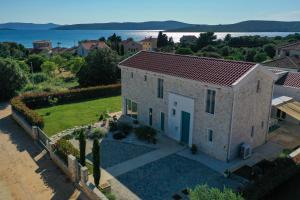 an aerial view of a house with a view of the water at Villa Vela Muline - 8 plus 2 guests - heated pool in Ugljan