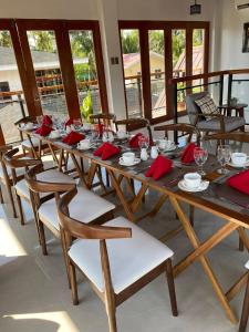 a long wooden table with red napkins and chairs at Casa Lucia Resort Hotel in Oslob