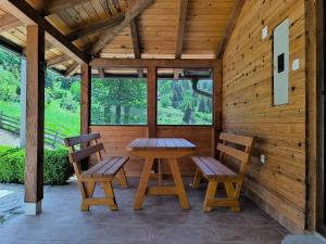 a wooden porch with two chairs and a table at Apartmani Slavko in Konjska Reka