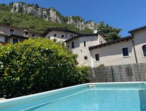 a swimming pool in front of a building with a mountain at Villetta Moscal- Buon Gusto in Affi