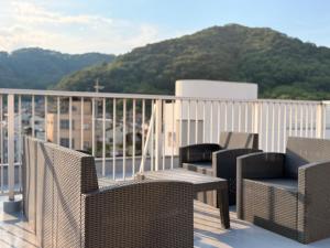 eine Gruppe von Stühlen und Tischen auf einem Balkon in der Unterkunft ura tsumo in Kasaoka