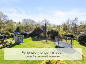 a backyard with a trampoline in the grass at Ferienwohnung Wieben Sankt Peter-Ording in Böhl