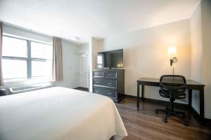 a hotel room with a bed and a desk and a television at Extended Stay America Suites - Norwalk - Stamford in Norwalk +16 photos