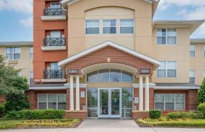 a large apartment building with a front door at Extended Stay America Suites - Columbia - Columbia Corporate Park in Columbia