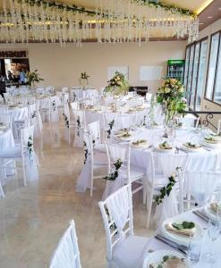 a room full of tables with white chairs and flowers at Rajacki konaci in Polom