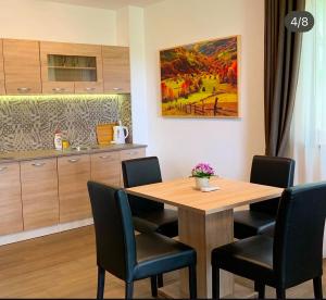 a dining room table with chairs and a painting on the wall at Rajacki konaci in Polom +11 photos