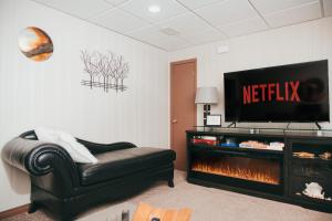 a living room with a couch and a tv and a fireplace at YEG Chic Luxury Accommodation in Edmonton