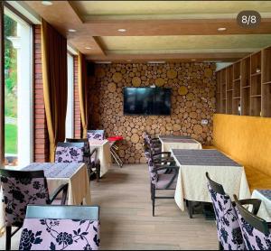 a restaurant with tables and chairs and a tv on a wall at Rajacki konaci in Polom