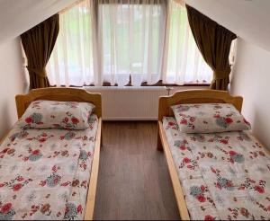 two twin beds in a room with a window at Rajacki konaci in Polom