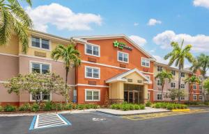 a hotel with palm trees in a parking lot at Extended Stay America Suites - West Palm Beach - Northpoint Corporate Park in West Palm Beach