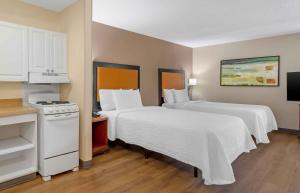 a hotel room with two beds and a stove at Extended Stay America Suites - West Palm Beach - Northpoint Corporate Park in West Palm Beach