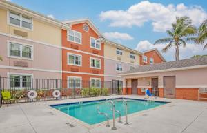a swimming pool in front of a apartment building at Extended Stay America Suites - West Palm Beach - Northpoint Corporate Park in West Palm Beach