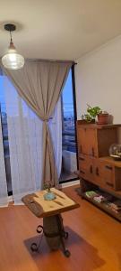 a living room with a table and a window at Acogedor departamento en La Serena in La Serena