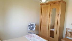 a bedroom with a bed and a wooden cabinet at Chalet with roof pool view in Dawwār ‘Abd Allāh