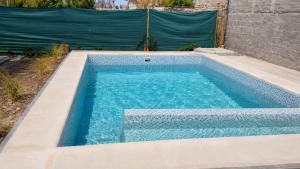 a swimming pool with blue water in a backyard at Nido del Sol in Pocito