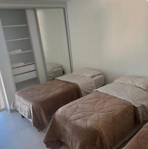 a bedroom with two beds and a mirror at The View Comodoro in Comodoro Rivadavia