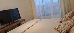 a bedroom with a bed with a flat screen tv at Acogedor departamento en La Serena in La Serena