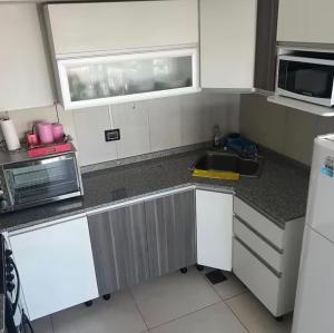 a small kitchen with a sink and a microwave at The View Comodoro in Comodoro Rivadavia