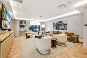 a living room with white furniture and a tv at The York Suite Miami in Miami