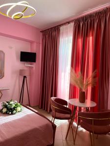 a bedroom with red curtains and a bed and a table at Bella Vista in Bali