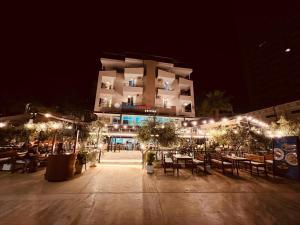 a building with tables and chairs at night at Hotel Liburnia Vitamin Aga in Golem