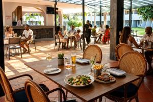 a table with a plate of food and people sitting at a restaurant at Sundown Country Estate in Boshoek