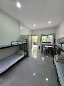 a room with three bunk beds and a table at MAOS Building in Batangas City