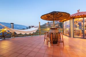 a patio with a table and an umbrella at Quinta da Eira do Prado in Carvalho