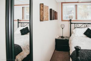a bedroom with two beds and a mirror at YEG Chic Luxury Accommodation in Edmonton