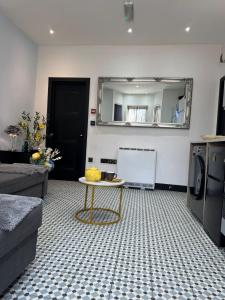 a living room with a table and a mirror at Dove & Gold in Gloucestershire