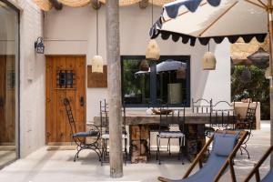 a patio with a table and chairs and an umbrella at Casa Do Ti Gil in Aldeia do Meco