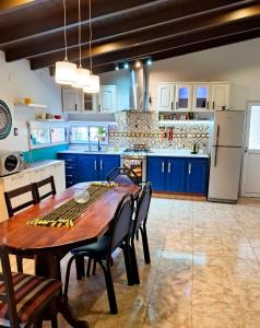a kitchen with blue cabinets and a wooden table and chairs at Casademontaña in Belén