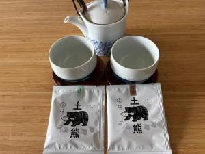 a table with two cups and a tea pot at Guesthouse Yoichi in Yoichi