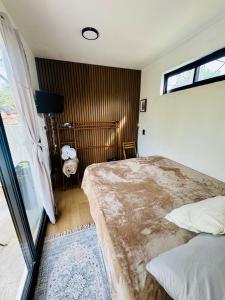 ein Schlafzimmer mit einem großen Bett und einem Fenster in der Unterkunft Pinecone box in Mazamitla