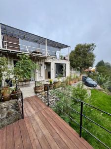 ein Haus mit einer Holzterrasse vor dem Hof in der Unterkunft Pinecone box in Mazamitla
